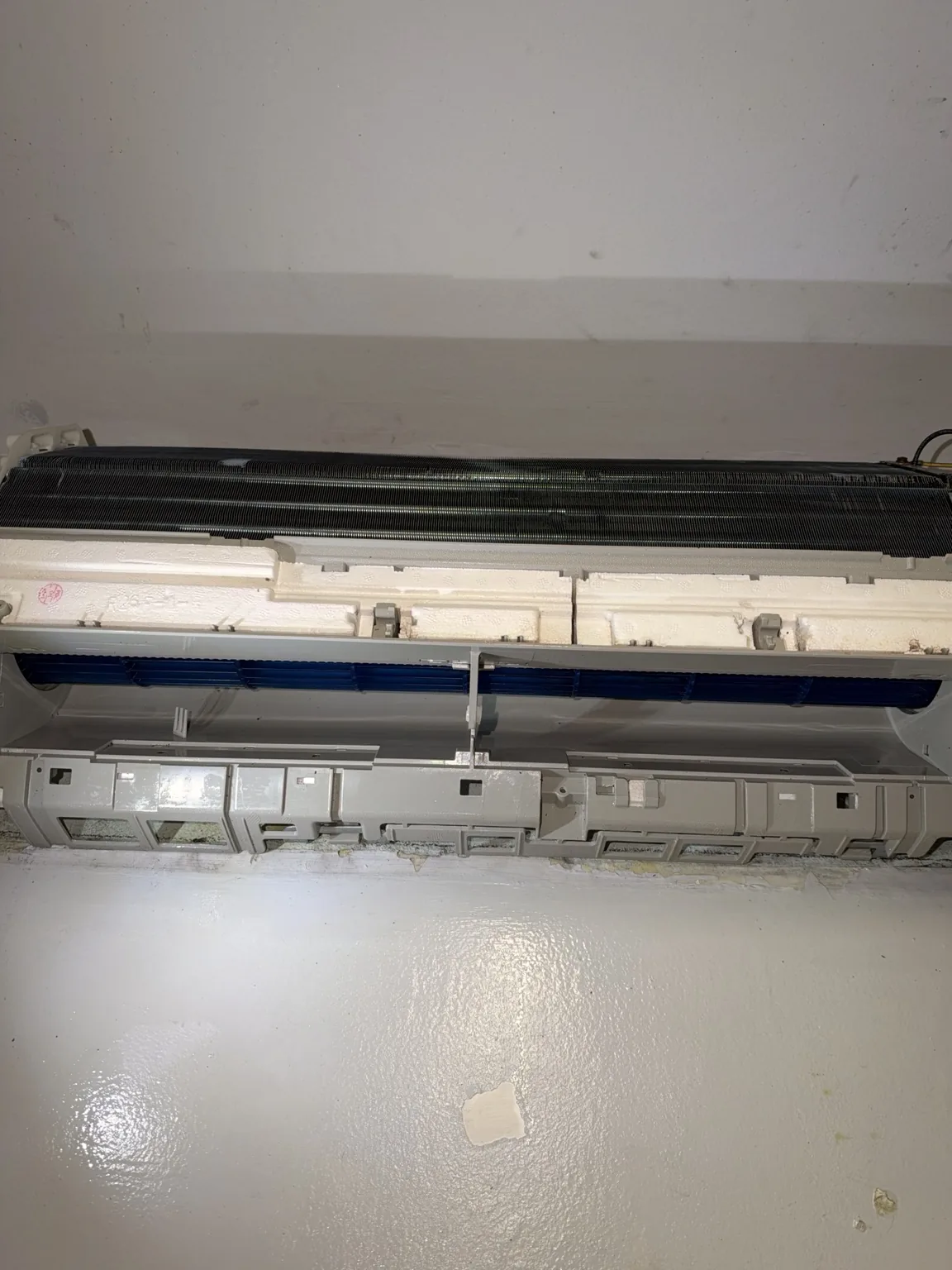 Wide view of the exposed mini-split coil, blower and cabinet