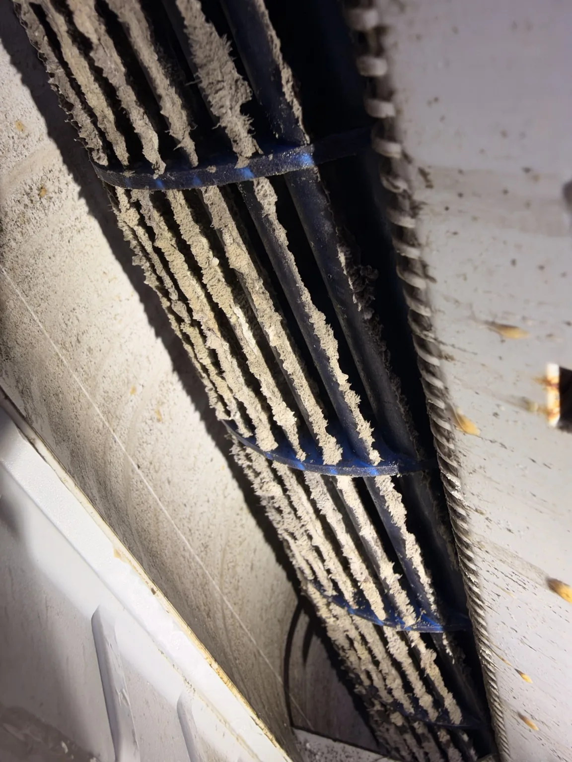 Close-up of accumulated debris on a blue mini-split blower wheel