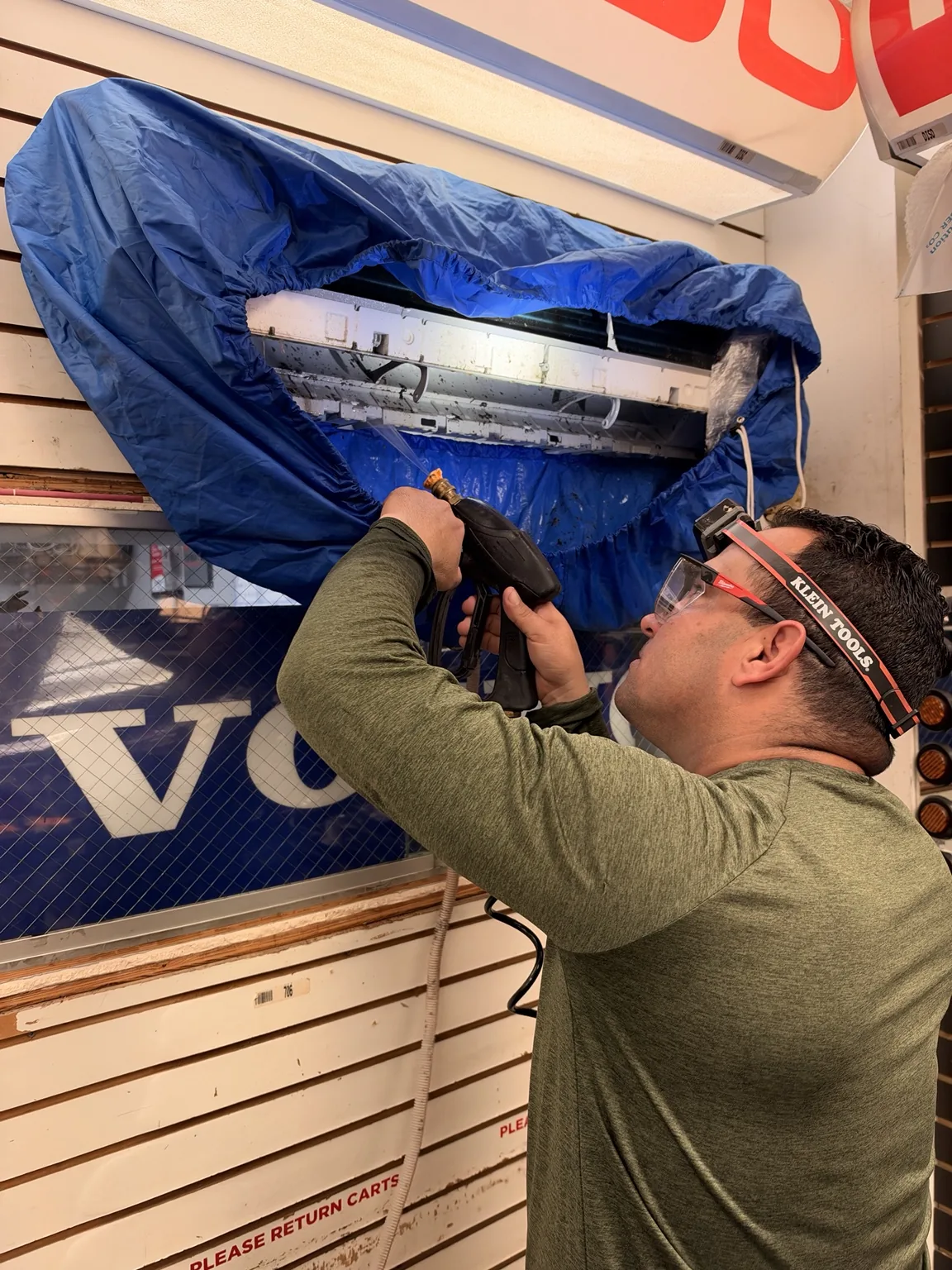Technician cleaning a mini-split with a protective wash bag