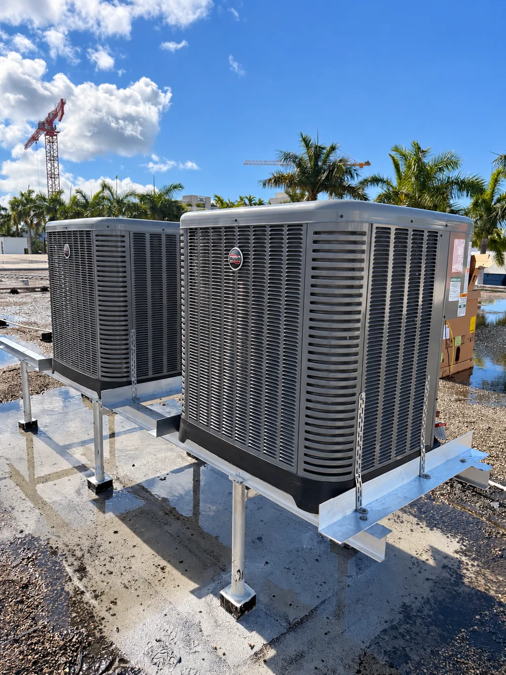 Two RUUD outdoor condensers on elevated rooftop stands